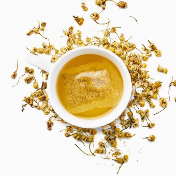 Tasse de tisane avec un sachet d'infusion de camomille sur fond de camomille séchée Tasse de tisane avec un sachet d'infusion de camomille sur fond de camomille séchée